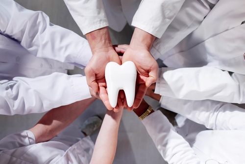 Group,Of,Dentists,Holding,Tooth.,Dental,Teeth,Whitening